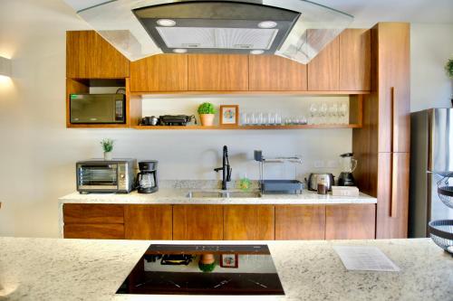 a kitchen with wooden cabinets and a counter top at Casa pavo real 350 MBS in Mérida