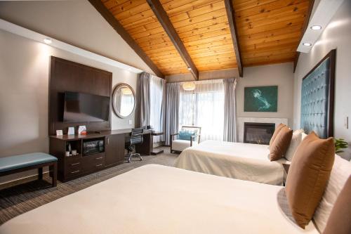 a hotel room with two beds and a flat screen tv at Munras Inn in Monterey