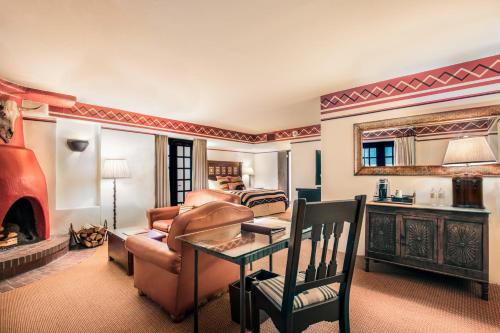 a living room with a couch a table and a fireplace at Inn & Spa at Loretto in Santa Fe