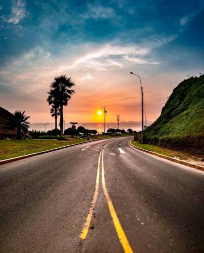 an empty road with the sunset in the background at Maywa at Central Miraflores in Lima