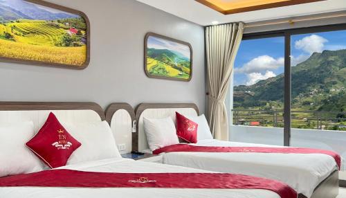 two beds in a room with a large window at En Hotel Sapa in Sa Pa