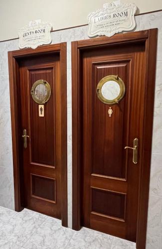 two brown wooden doors in a building at Hostal Barco da Vella in Merejo
