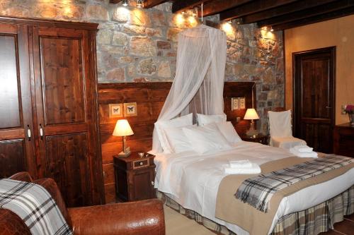 a bedroom with a bed with a mosquito net at Guest Stone Houses in Aidona in Aïdón