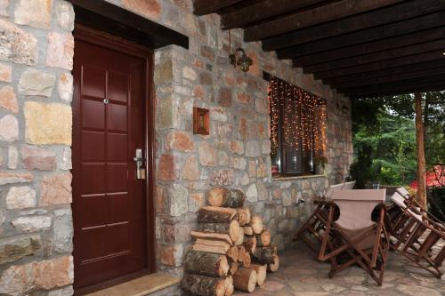 a stone house with a door and a stack of logs at Guest Stone Houses in Aidona in Aïdón