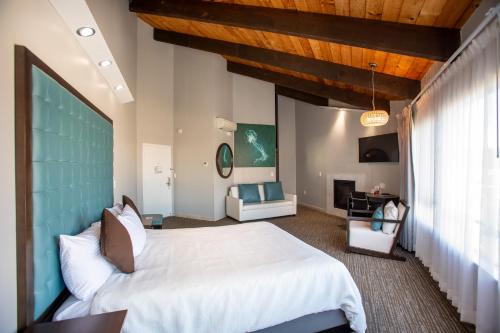 a bedroom with a large white bed and a desk at Munras Inn in Monterey
