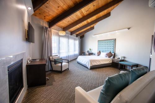 a bedroom with a bed and a couch and a tv at Munras Inn in Monterey