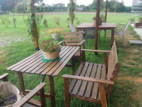 a wooden picnic table and chairs with flowers on it at Al Cjant dal Gjal affittacamere a San Daniele in Ragogna