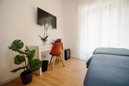 a bedroom with a bed and a chair and a tv at Sweet Dreams in Civitavecchia