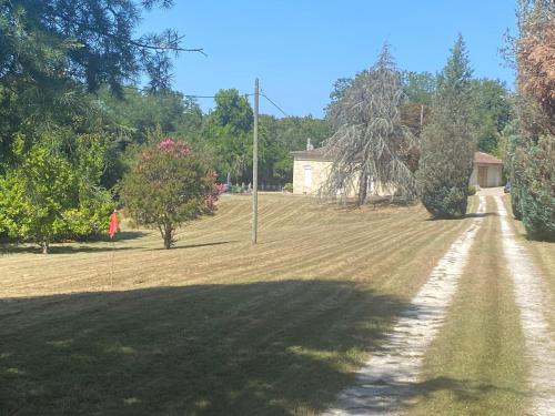 a field of grass with a dirt road at Domaine de La Mouleyre à Cénac proche Bordeaux in Carignan