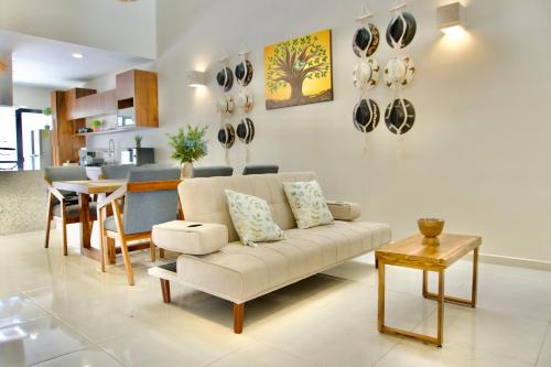 a living room with a couch and a table at Casa árbol 350 MBS in Mérida