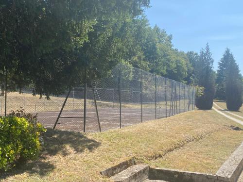 une clôture à maillons avec un court de tennis derrière elle dans l'établissement Domaine de La Mouleyre à Cénac proche Bordeaux, à Carignan