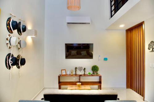 a living room with a couch and a tv on a wall at Casa árbol 350 MBS in Mérida