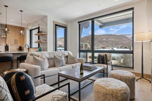 エイボンにあるOne Riverfront Condo 405 by East West Hospitalityのソファと椅子とテーブルのあるリビングルーム