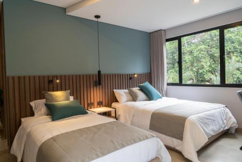 a bedroom with two beds and a window at Hotel Living 35 Suites in Medellín