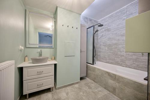 a white bathroom with a sink and a shower at Le cocon bohème chic in Sartrouville