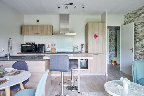 une cuisine et un salon avec une table et des chaises dans l'établissement Le cocon bohème chic, à Sartrouville