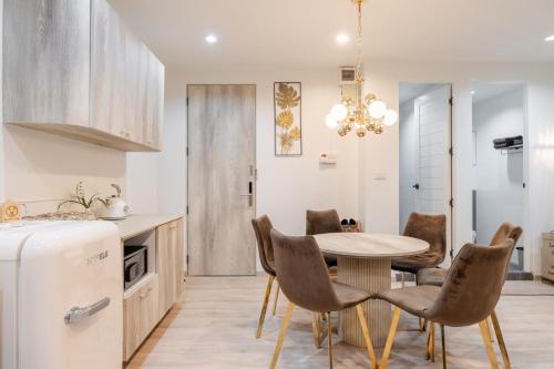 a kitchen and dining room with a table and chairs at FM Ratchada in Ban Na Song