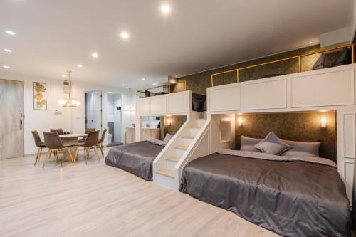 a bedroom with two beds and a dining table at FM Ratchada in Ban Na Song
