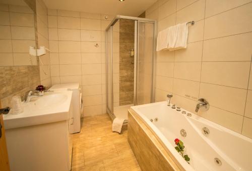 ein Badezimmer mit einer Badewanne und einem Waschbecken in der Unterkunft Flachauer Bergkristall in Flachau