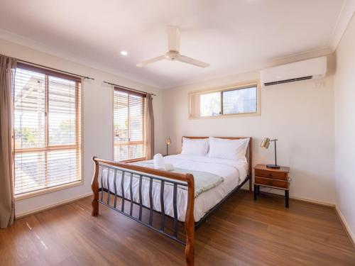 a bedroom with a bed and two windows at Peaceful 4B2B Sweet Home w Backyard at Springfield in Springfield Lakes