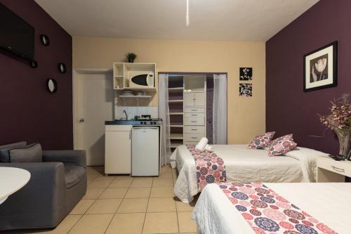a hotel room with two beds and a kitchen at Satya Suites & Portal San Angel Flats in Mexico City