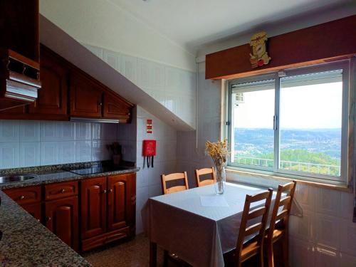 una cucina con un tavolo con un vaso di fiori sopra di Alvão Sunrise - Natural Park a Vila Real