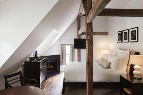 a bedroom with a white bed and a fireplace at Bedford Post Inn in Bedford