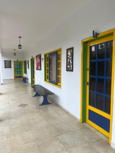 a hallway with doors and a bench in a building at Finca Hotel Andaquies in Armenia