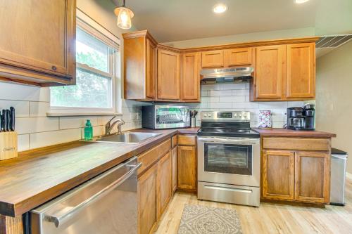 a kitchen with wooden cabinets and stainless steel appliances at On-Site Lake Access Pet-Friendly Vinita Home in Disney
