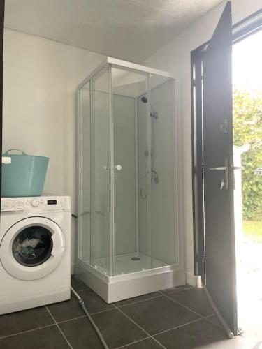 La salle de bains est pourvue d'un lave-linge et d'une douche en verre. dans l'établissement Villa Angoulême, à Saint-Yrieix-sur-Charente