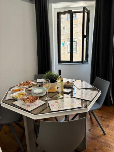 a table with food and wine glasses and a window at Casa Eliza in Aldeia das Dez
