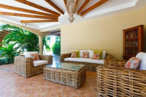 a living room with wicker chairs and a table at Boutique Surf Hotel Rip Jack Inn in Playa Grande