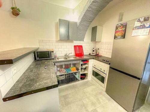 une petite cuisine avec un réfrigérateur et un évier dans l'établissement Maison de village, Aups, Verdon, à Aups