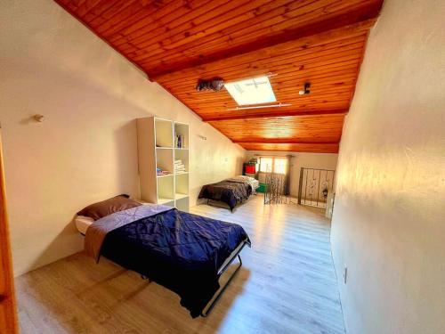 une chambre avec deux lits dans une pièce avec des plafonds en bois dans l'établissement Maison de village, Aups, Verdon, à Aups