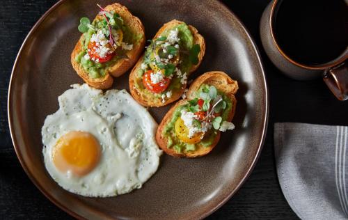 a plate of eggs and toast with tomatoes and avocado at Renaissance Mobile Riverview Plaza Hotel in Mobile