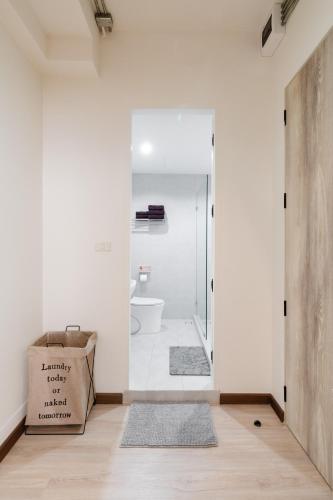 a bathroom with a toilet and a glass door at FM Ratchada in Ban Na Song