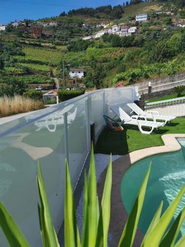 a view of a balcony with a pool and a chair at Casa Das Origens, vue sur la vallée du Douro in Mesão Frio