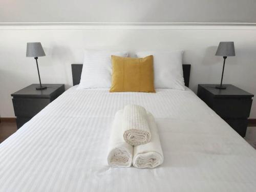 a white bed with two towels on top of it at Casa Das Origens, vue sur la vallée du Douro in Mesão Frio