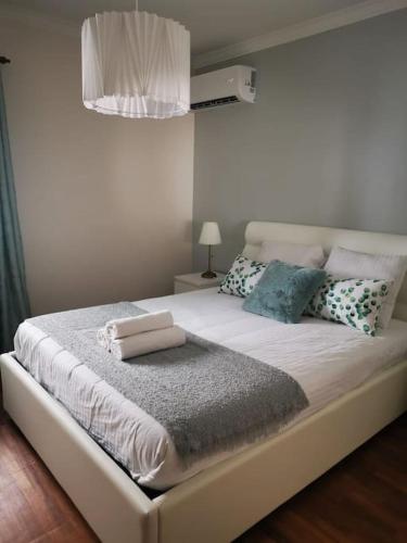 a bedroom with a large white bed with pillows at Casa Das Origens, vue sur la vallée du Douro in Mesão Frio