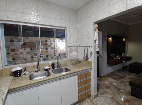 a bathroom with two sinks and a large window at Chalé Luxuoso in Caldas Novas