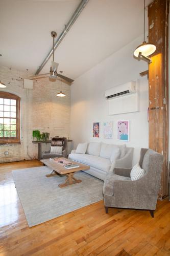 a living room with a white couch and a table at Dollys Downtown Loft Knoxville in Knoxville