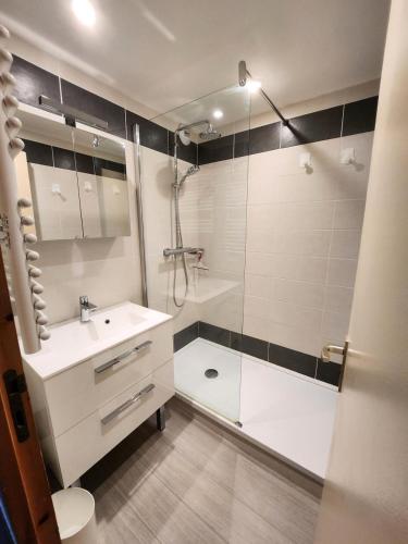 une salle de bain blanche avec une douche et un lavabo dans l'établissement Résidence Le De 1 - Deux pièces à proximité des pistes MAE-9541, à Aime La Plagne
