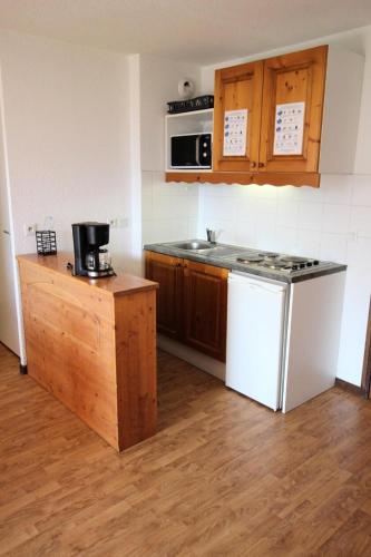 Il comprend une cuisine équipée d'une cuisinière et d'un réfrigérateur blanc. dans l'établissement Résidence Les Balcons De La Vanoise - LES BALCONS DE LA VANOISE - BV416 MAE-0371, à Villarodin-Bourget
