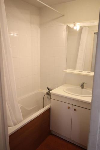 une salle de bain avec un lavabo, une baignoire et un miroir dans l'établissement Résidence Les Balcons De La Vanoise - LES BALCONS DE LA VANOISE - BV416 MAE-0371, à Villarodin-Bourget