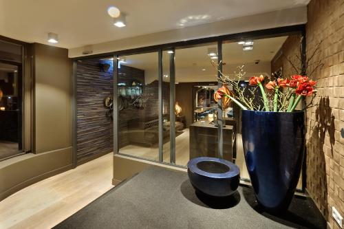 a lobby with a large blue vase with flowers in it at Amsterdam Forest Hotel in Amstelveen