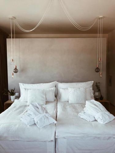 a white bed with white sheets and pillows on it at AVLiving City LOFT Basel in Basel