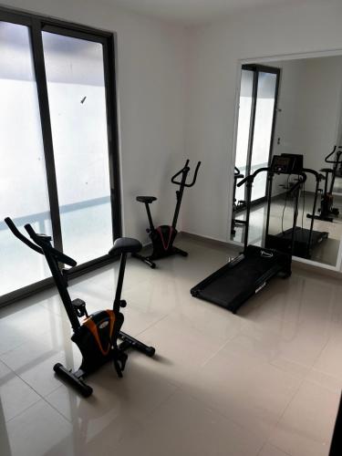 a gym with cardio bikes and ellipticals in a room at Hermoso Penthouse in Tuxtla Gutiérrez