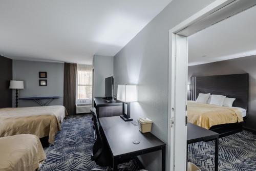 a hotel room with two beds and a mirror at Quality Inn Olive Branch in Olive Branch