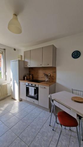 une cuisine avec une table et un réfrigérateur blanc dans l'établissement Logement spacieux Strasbourg proche centre-ville, à Strasbourg
