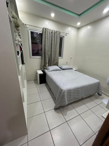 ein Schlafzimmer mit einem Bett und einem gefliesten Boden in der Unterkunft Smile Parque das Flores in Manaus